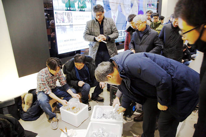 YTN 구성원들이 지난 19일 오전 서울 상암 YTN 사옥 1층 로비에서 ‘최남수 사장 출근저지 투쟁’ 참여에 앞서 아침으로 먹을 주먹밥을 나누고 있다.  (언론노조 YTN지부 제공)  