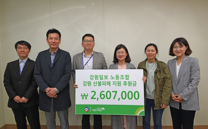 강원일보 노동조합이 지난 18일 노조사무실에서 고주애 초록우산어린이재단 강원지역본부장에게 강원산불 피해 지원금을 전달한 모습(강원일보 노조 제공)  