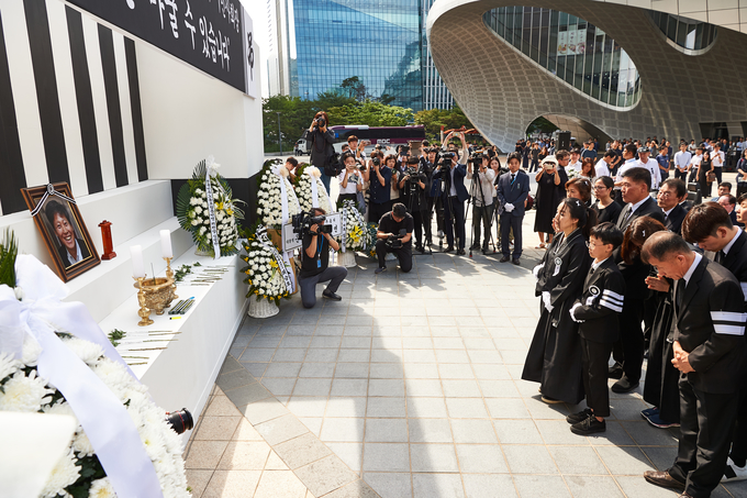 고 이용마 MBC기자의 영결식 '세상은 바꿀 수 있습니다' 시민사회장이 23일 서울 상암 MBC 앞 광장에서 열렸다. 식 막바지 유족이 헌화를 하고 있다. 배우자 김수영 씨와 아들 헌재, 경재. (언론노조 MBC본부) 고 이용마 MBC기자의 영결식 '세상은 바꿀 수 있습니다' 시민사회장이 23일 서울 상암 MBC 앞 광장에서 열렸다. 식 막바지 유족이 헌화를 하고 있다. 배우자 김수영 씨와 아들 헌재, 경재. (언론노조 MBC본부)
