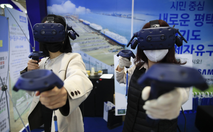 지난 9일 서울 강남구 코엑스에서 열린 한국전자전에서 참가자들이 VR 활쏘기 게임을 즐기고 있는 모습. /뉴시스 