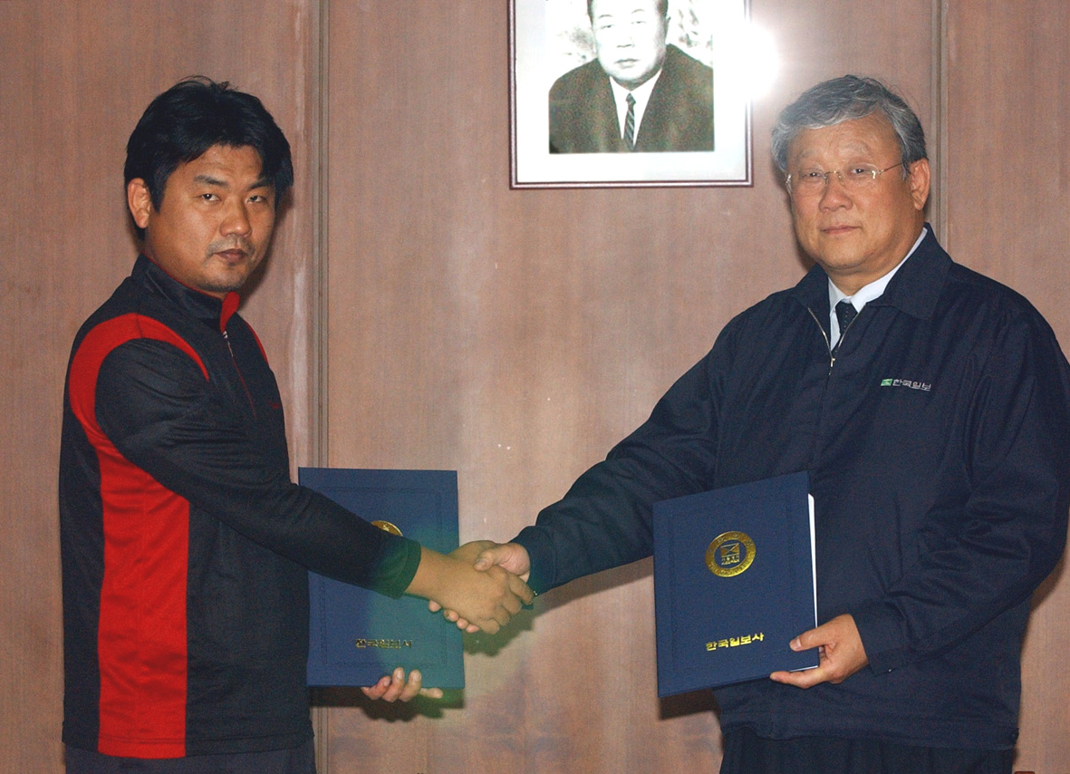 한국일보 장재구 회장(오른쪽)과 전민수 노조위원장이 8일 임단협 합의서에 서명한 뒤 악수를 나누고 있다.