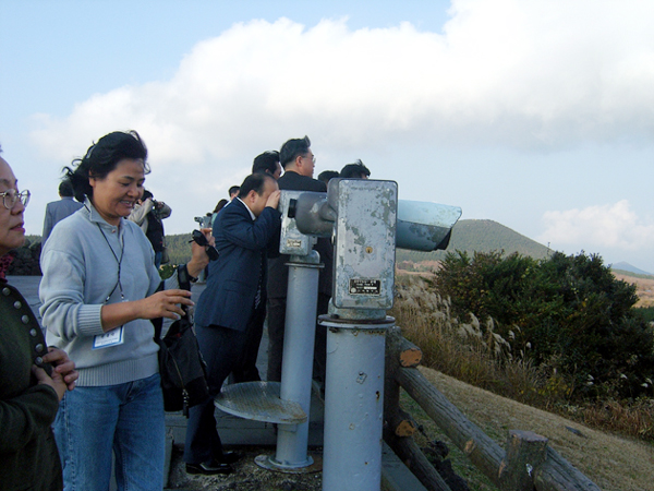 제주관광에 나선 재외동포 기자들이 제주도 ‘산굼부리’를 찾아 갈대밭 등 주변 광경을 둘러보고 있다.