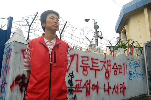 굳게 닫힌 회사 문 앞에 선 김소연 금속노조 기륭전자 분회장. 전시를 방불케 하는 철조망과 구호가 기륭전자 노동자들의 험난했던 지난날을 말해주는 듯하다. 사진=장우성 기자